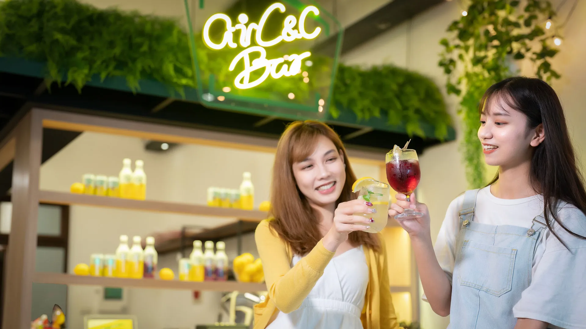 airC&C Bar 霓虹招牌下兩位女生舉杯調飲